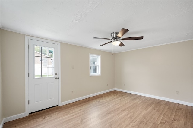 interior space with ornamental molding, light wood-type flooring, ceiling fan, and a textured ceiling