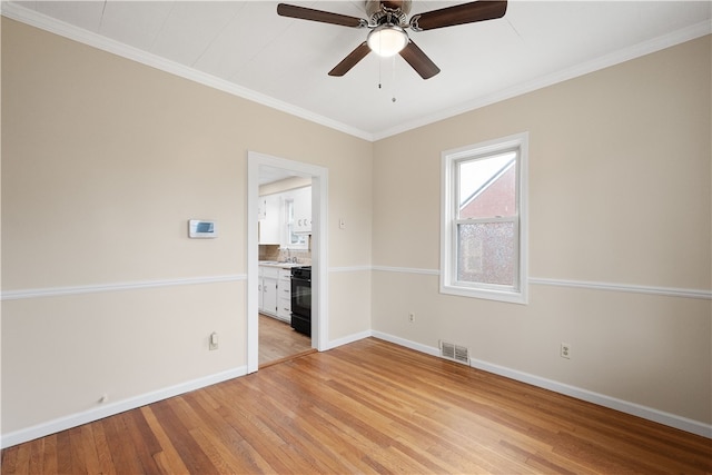 spare room with ceiling fan, sink, light wood-type flooring, and ornamental molding