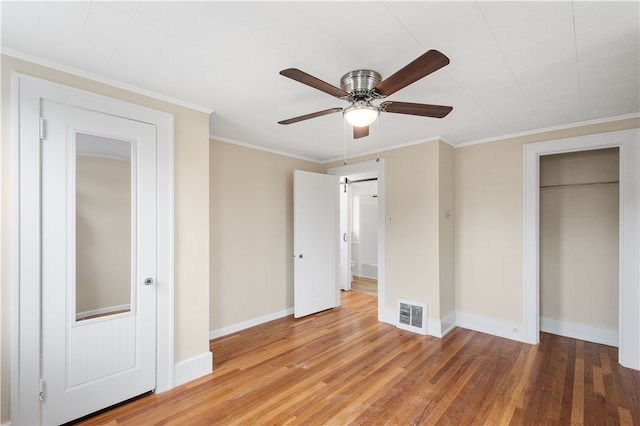 unfurnished bedroom featuring wood-type flooring, crown molding, and ceiling fan