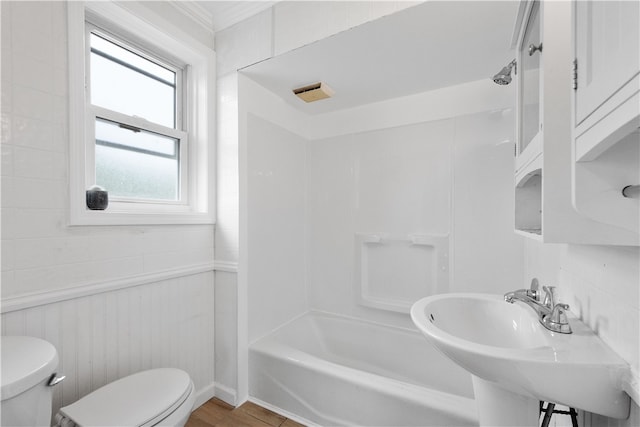 full bathroom with wood-type flooring, sink, bathing tub / shower combination, and toilet