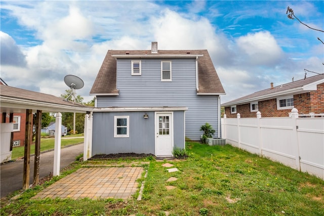 back of property with a patio and a yard