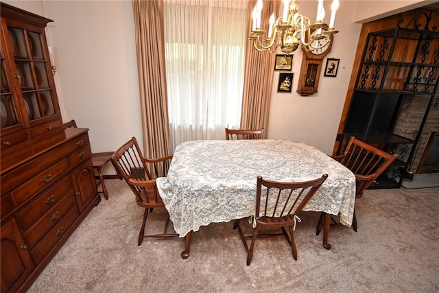 dining space featuring an inviting chandelier and light carpet