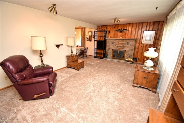 carpeted living room featuring a fireplace and wood walls