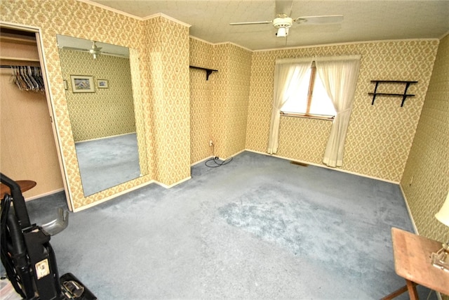 unfurnished bedroom with ceiling fan, a closet, crown molding, and carpet flooring