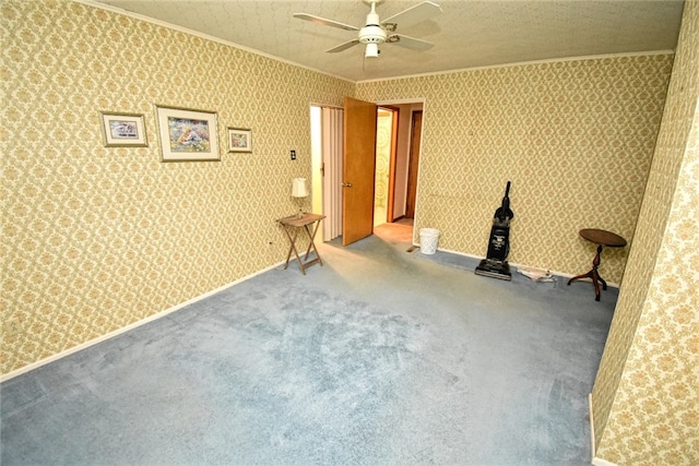 carpeted empty room with ornamental molding, ceiling fan, and a textured ceiling