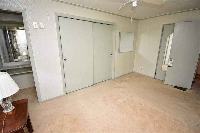 unfurnished bedroom with ceiling fan, light colored carpet, and a closet