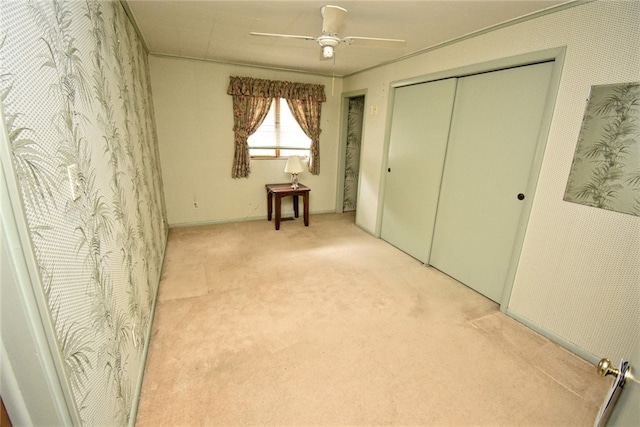 unfurnished bedroom with ceiling fan, a closet, and light carpet