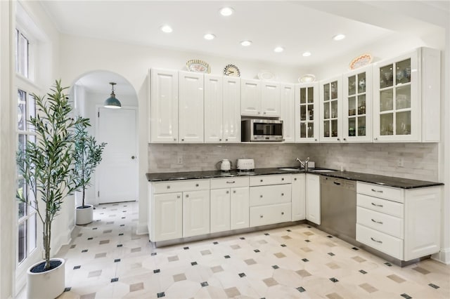 kitchen featuring decorative backsplash, white cabinets, appliances with stainless steel finishes, and sink