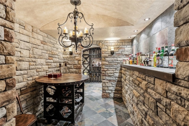 wine area with vaulted ceiling and a chandelier