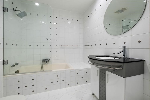 bathroom featuring tiled shower / bath, tile walls, sink, and tile patterned floors