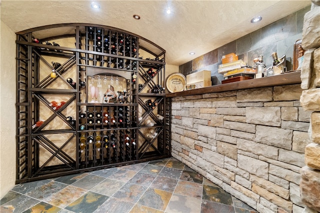 wine area featuring a textured ceiling