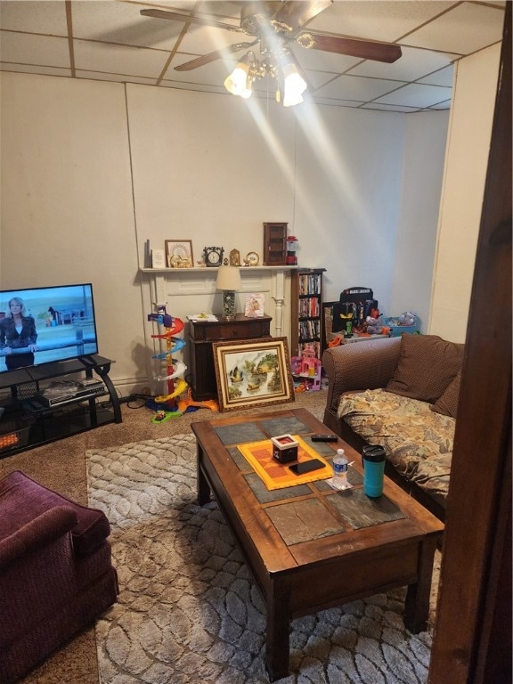 living room with ceiling fan, carpet floors, and a paneled ceiling