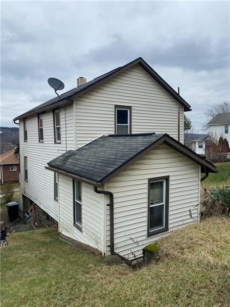 rear view of house featuring a lawn