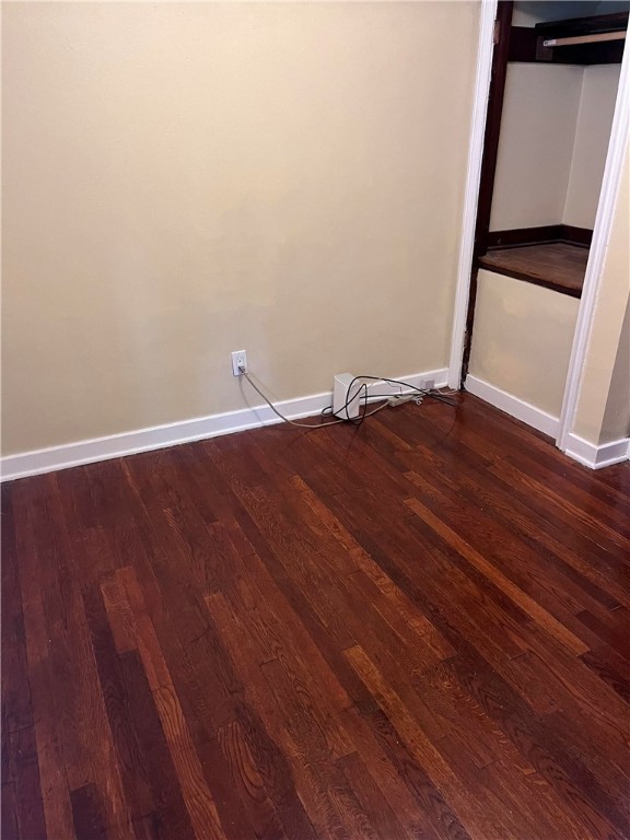 unfurnished bedroom with dark wood-type flooring