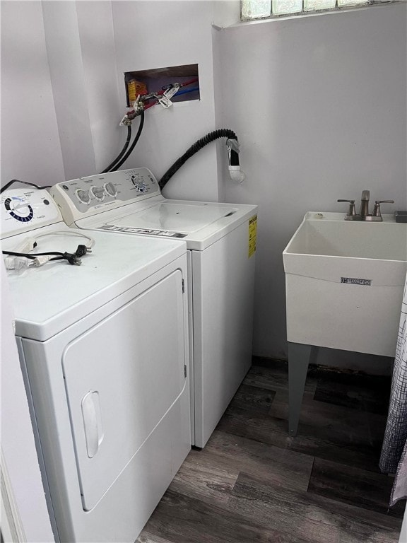 washroom featuring dark hardwood / wood-style floors, washer and clothes dryer, and sink