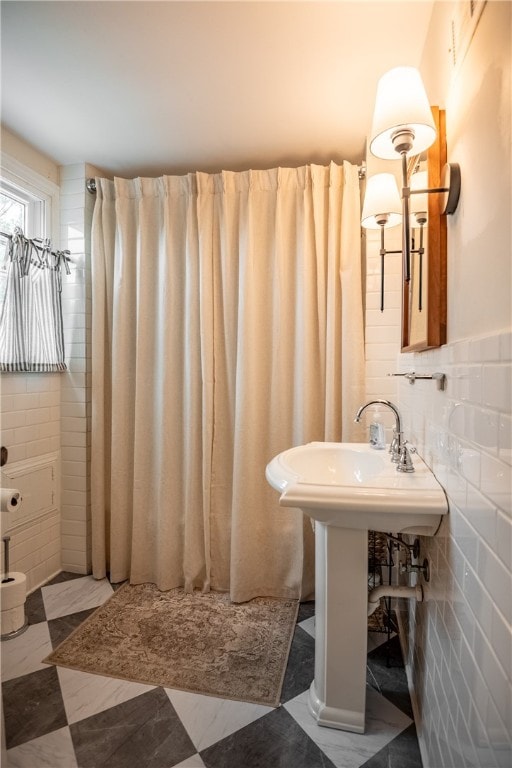 bathroom with walk in shower and tile walls