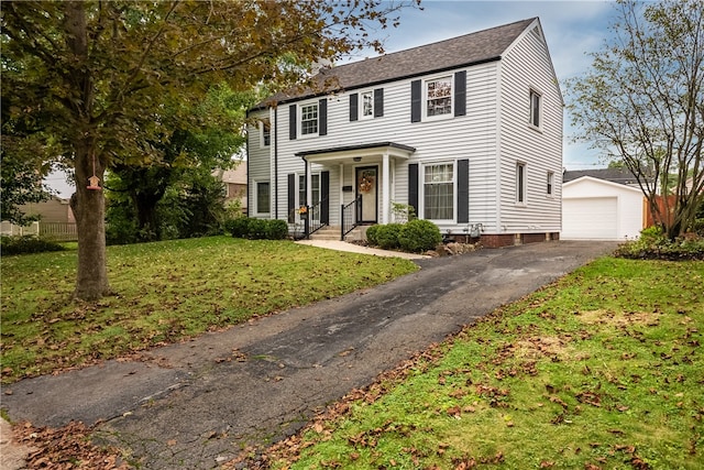 colonial house featuring an outdoor structure, a garage, and a front yard