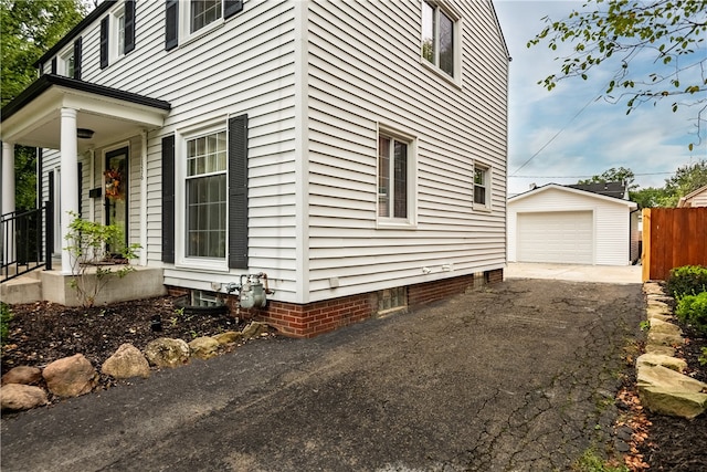 view of side of property with a garage and an outbuilding