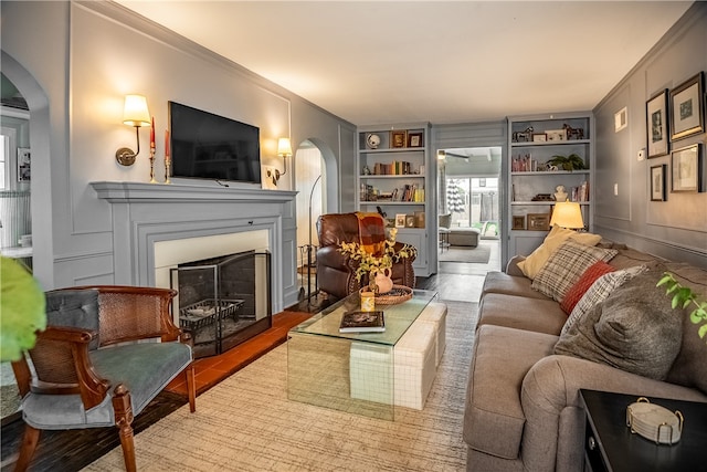 living room featuring crown molding, hardwood / wood-style floors, and built in features