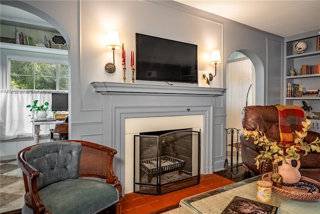 sitting room featuring built in shelves, tile patterned flooring, and crown molding