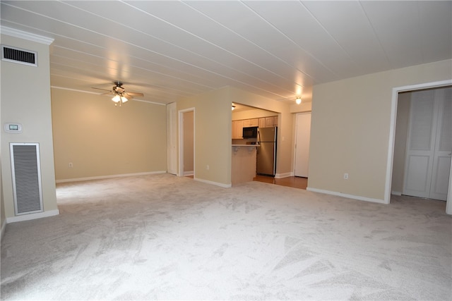 unfurnished living room featuring light carpet and ceiling fan