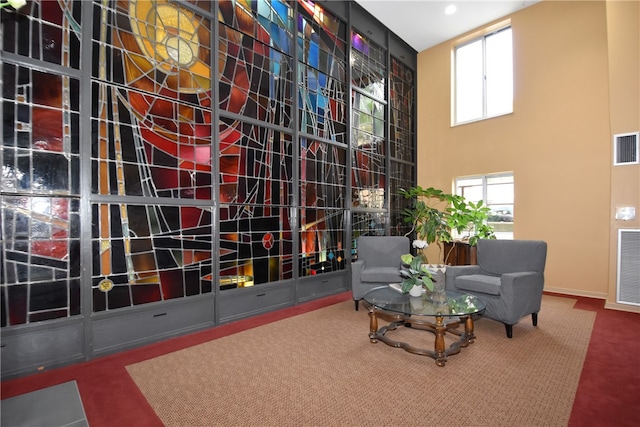 interior space featuring a towering ceiling and carpet flooring