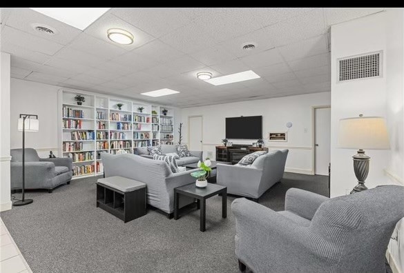 carpeted living room featuring a paneled ceiling