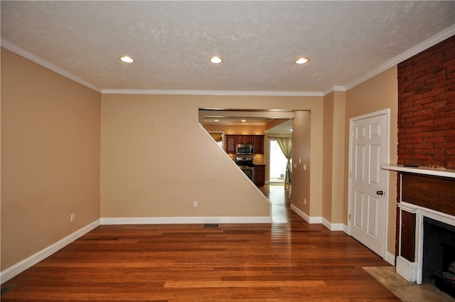 unfurnished living room featuring a textured ceiling, a fireplace, ornamental molding, and dark hardwood / wood-style floors