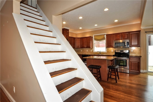 stairway featuring ornamental molding, hardwood / wood-style floors, and sink