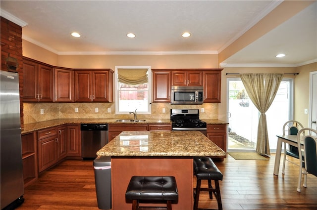 kitchen featuring sink, appliances with stainless steel finishes, dark wood-type flooring, and a kitchen island