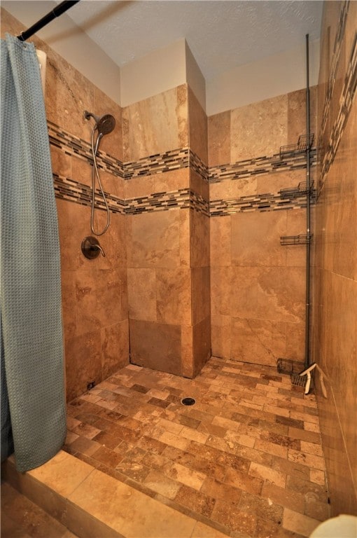 bathroom featuring a textured ceiling and curtained shower