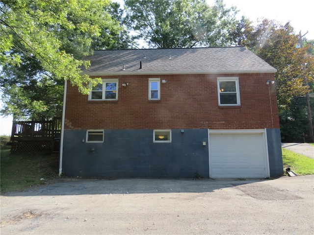 rear view of house with a wooden deck and a garage