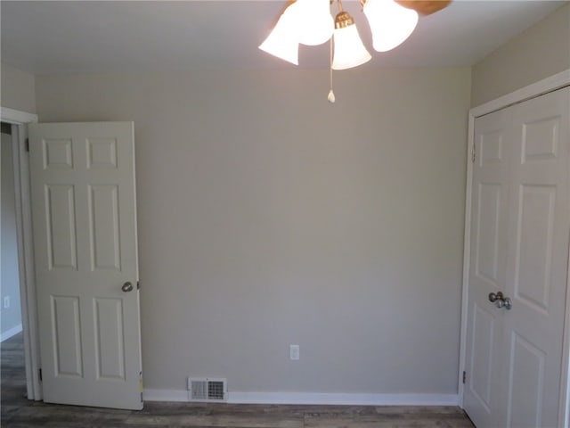 empty room with dark hardwood / wood-style floors and ceiling fan