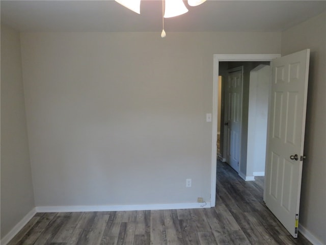 unfurnished room featuring dark wood-type flooring and ceiling fan