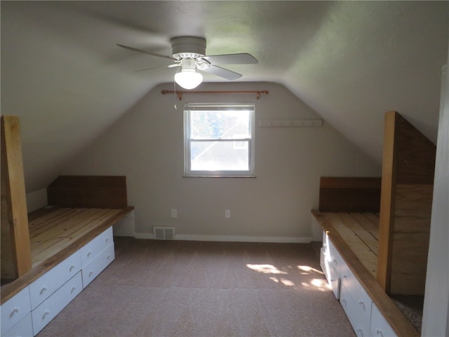 additional living space featuring ceiling fan, lofted ceiling, and light colored carpet