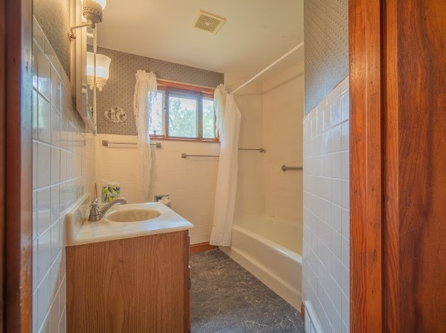 bathroom featuring vanity, shower / tub combo with curtain, and tile walls