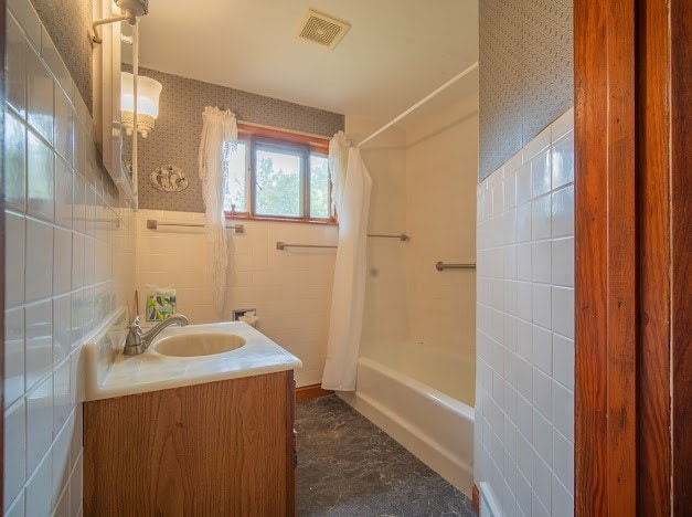 bathroom featuring shower / bath combo, vanity, and tile walls