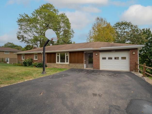 ranch-style home featuring a front lawn and a garage