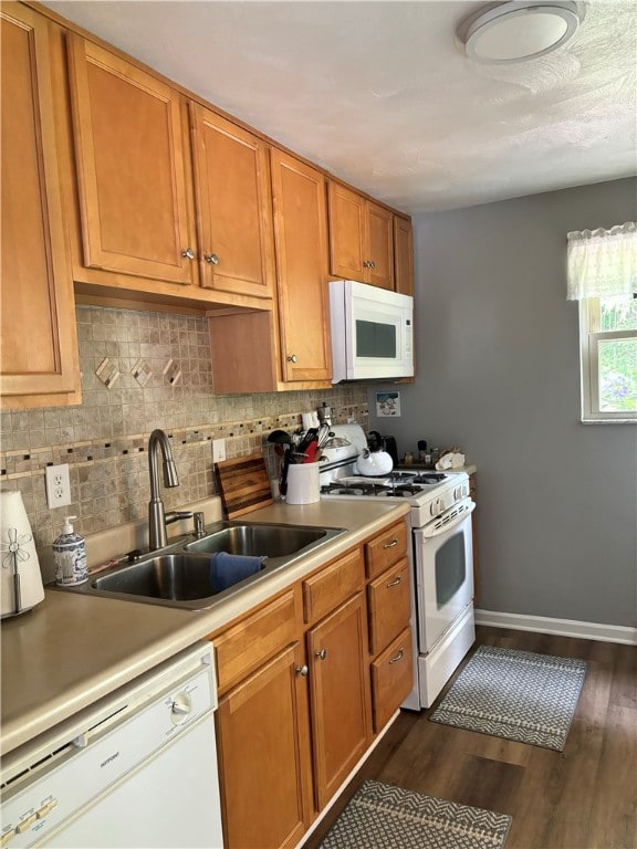 kitchen featuring sink, dark hardwood / wood-style flooring, white appliances, and tasteful backsplash