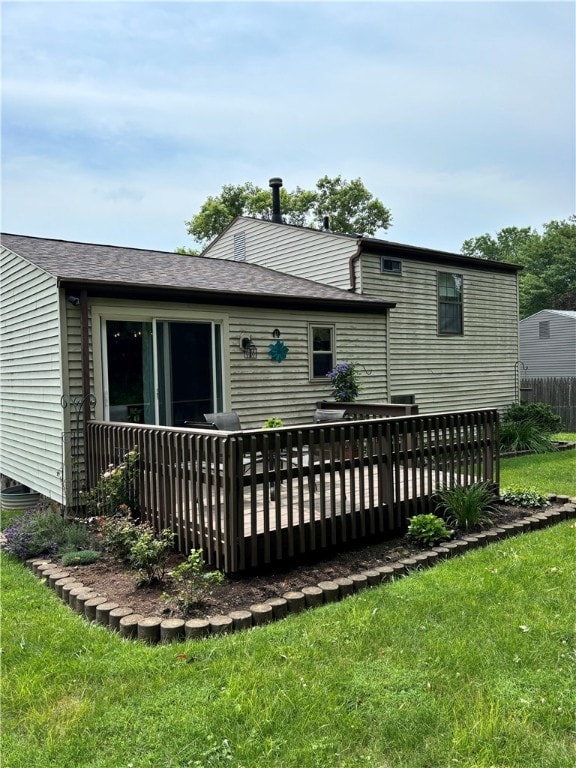 rear view of house with a yard and a wooden deck