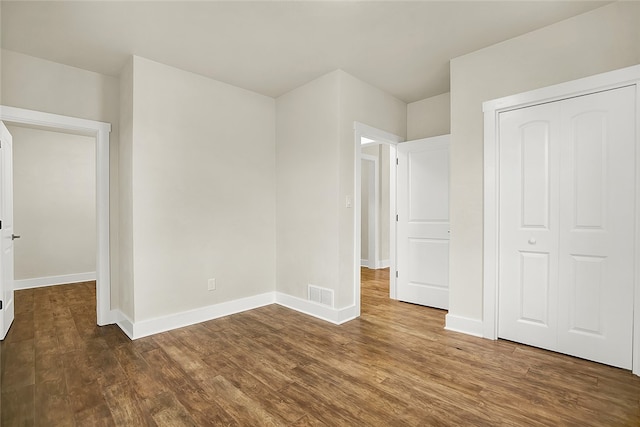 unfurnished bedroom featuring a closet and hardwood / wood-style floors