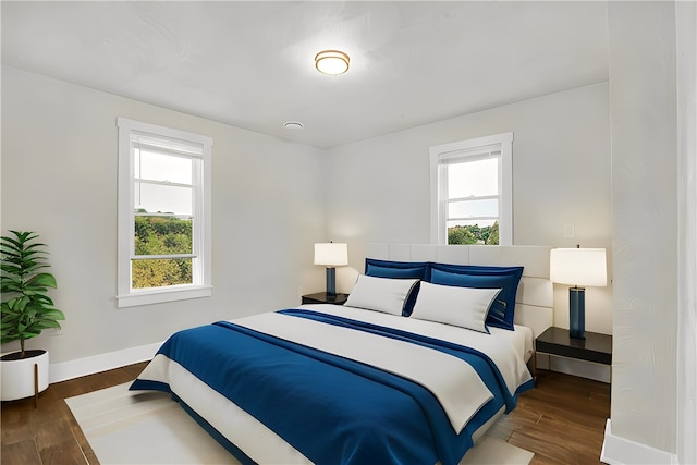 bedroom with multiple windows and dark hardwood / wood-style floors