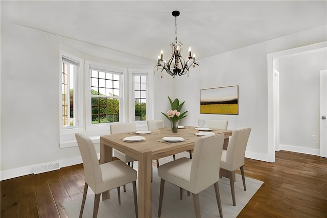 dining area with a notable chandelier and dark hardwood / wood-style floors