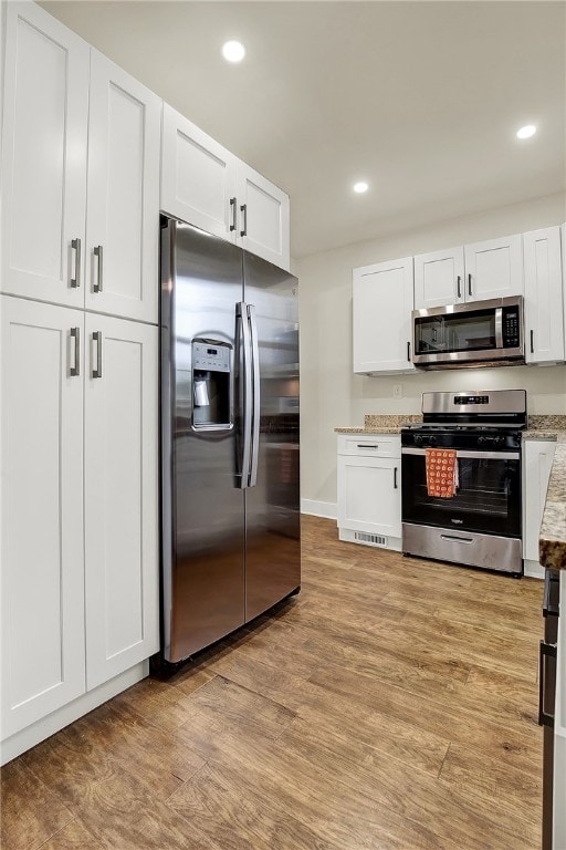 kitchen featuring light hardwood / wood-style flooring, stainless steel appliances, and white cabinets