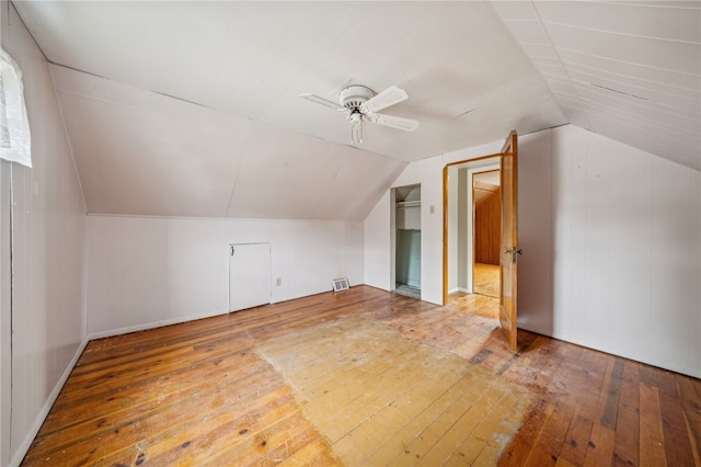 additional living space featuring wood-type flooring, lofted ceiling, and ceiling fan