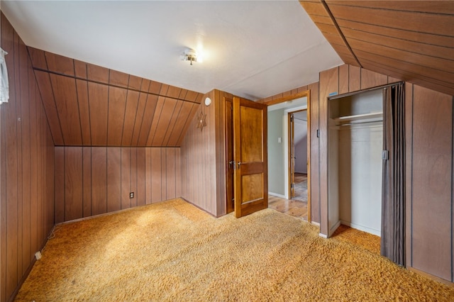 additional living space with light carpet, wooden walls, and lofted ceiling