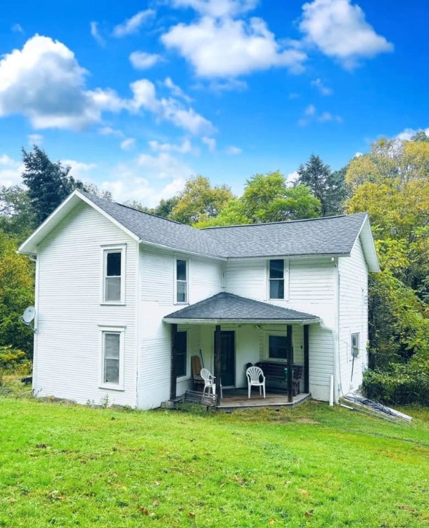 rear view of property featuring a lawn