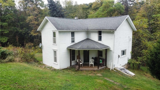 rear view of property with a yard