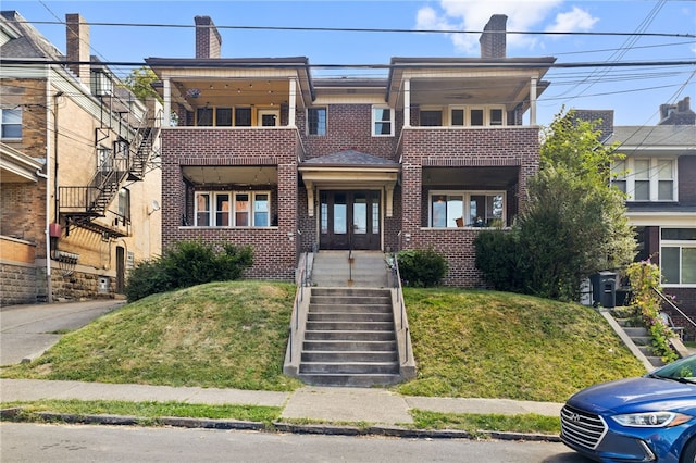 view of front facade featuring a balcony and a front lawn