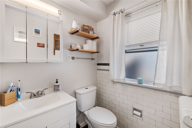 bathroom featuring radiator, vanity, tile walls, and toilet